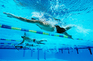 Male swimmers racing in pool, underwater view